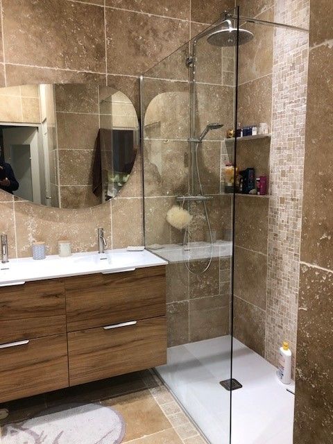 Salle de bains moderne avec meuble-lavabo en bois, grand miroir et cabine de douche en verre