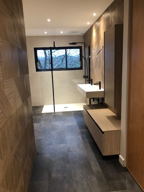 Salle de bains moderne et étroite avec lambris, lavabo suspendu et douche près d'une fenêtre