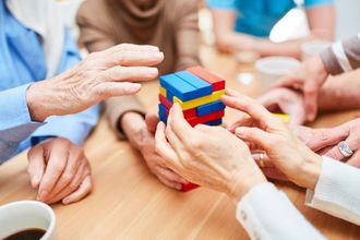 Mehrere Personen spielen gemeinsam Jenga