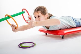 Mädchen auf einem Rollwagen bei einem Geschicklichkeitsspiel mit Ringen