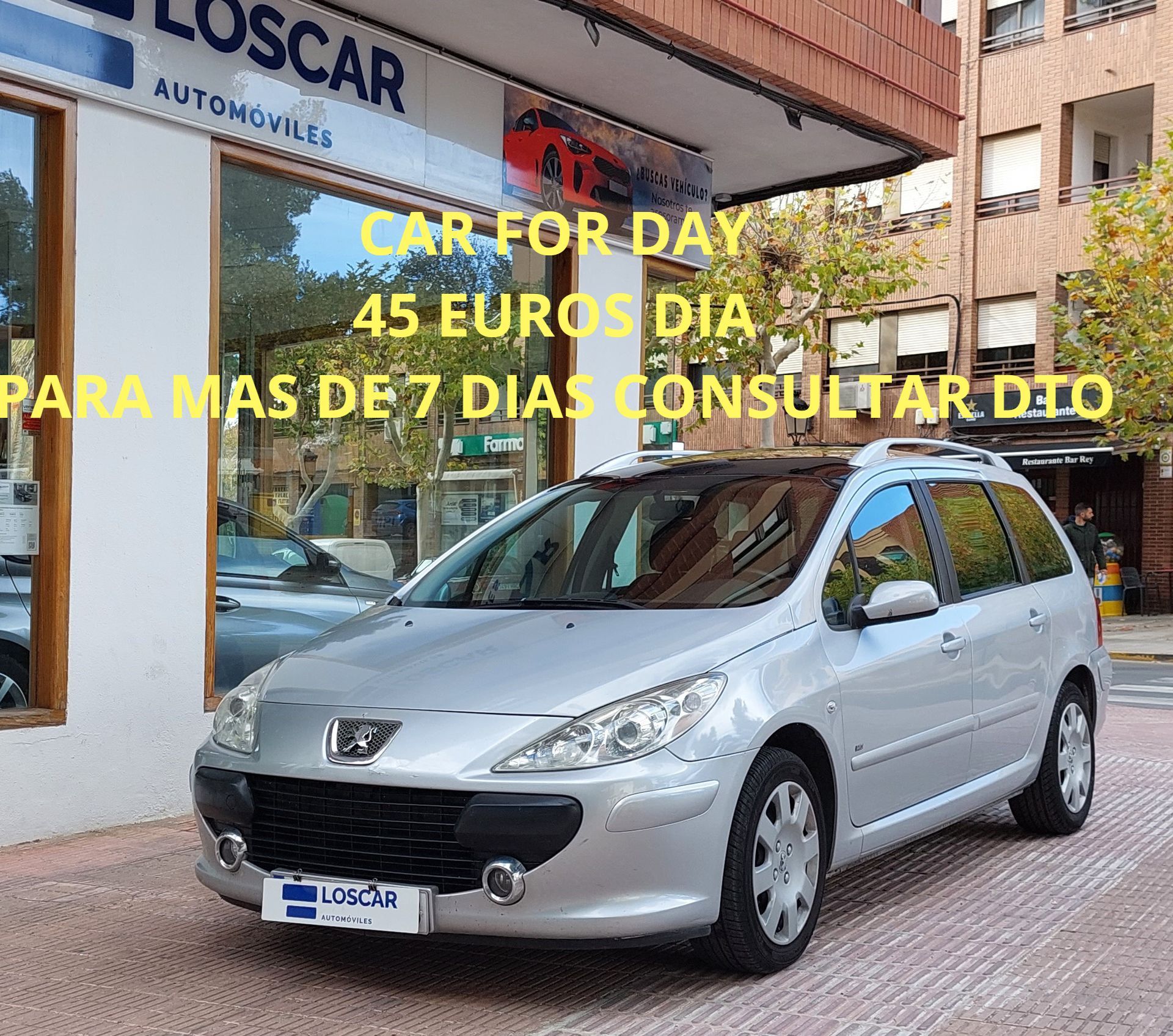 Peugeot 307 SW plateado aparcado delante de una tienda de Loscar Automóviles con un texto publicitario