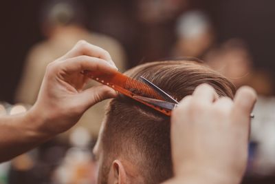 Friseur schneidet einem Mann mit einer Haarschneidemaschine die Haare, Nahaufnahme, in einem Salon.