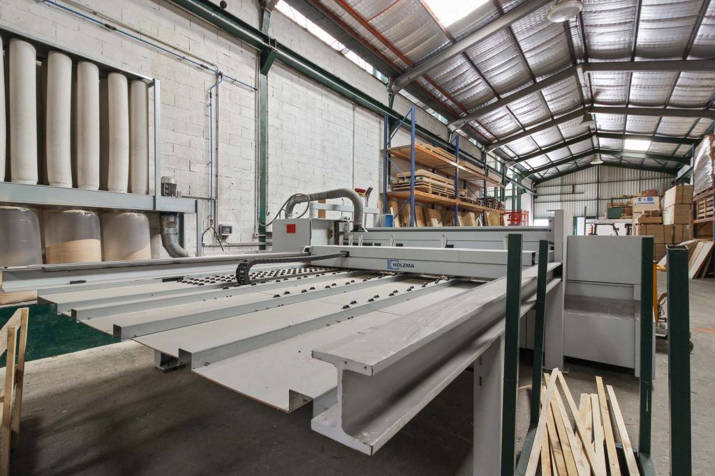 Grande machine industrielle de découpe du bois dans une usine.