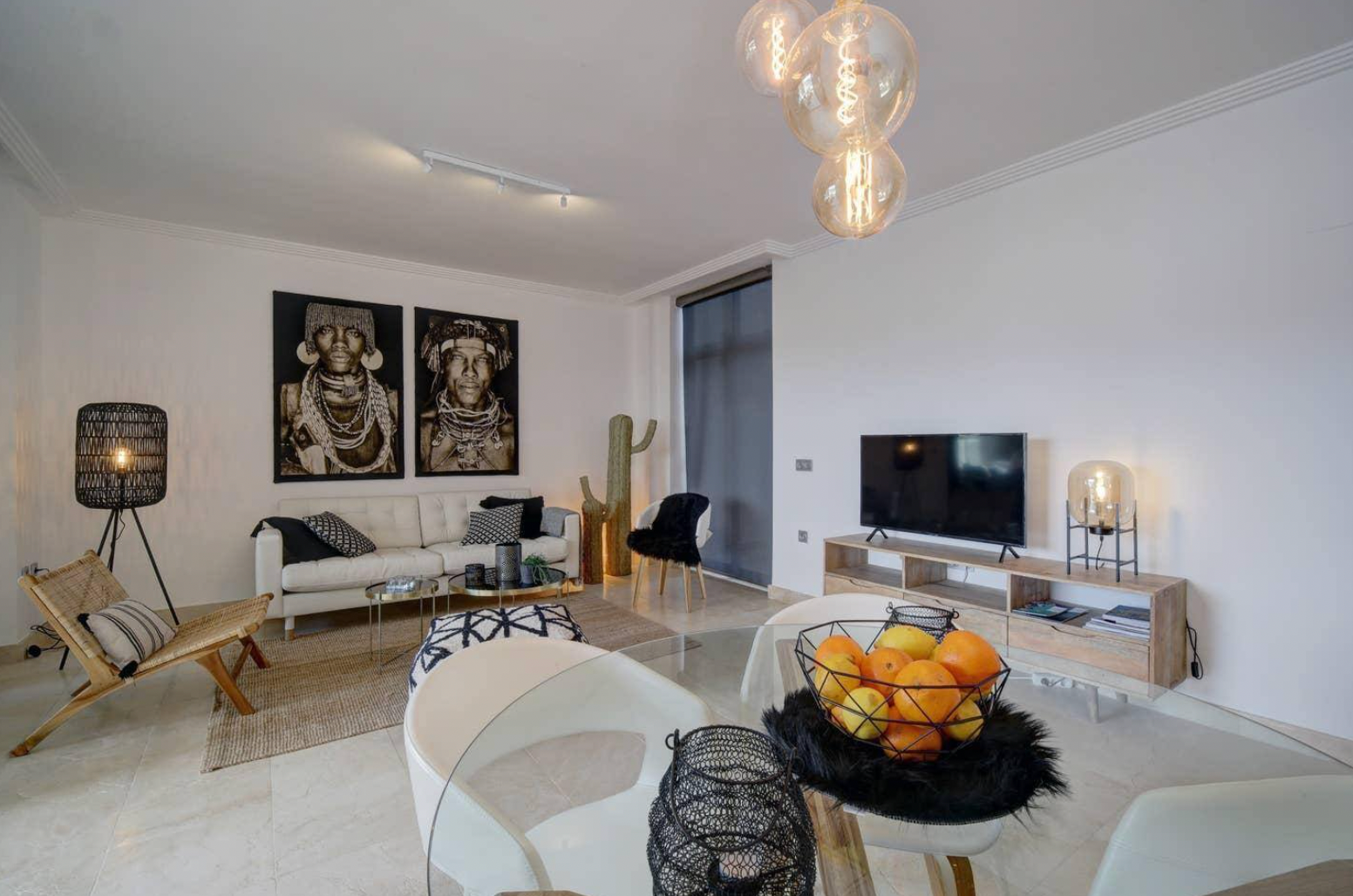 A living room with a couch , chairs , a table and a television.