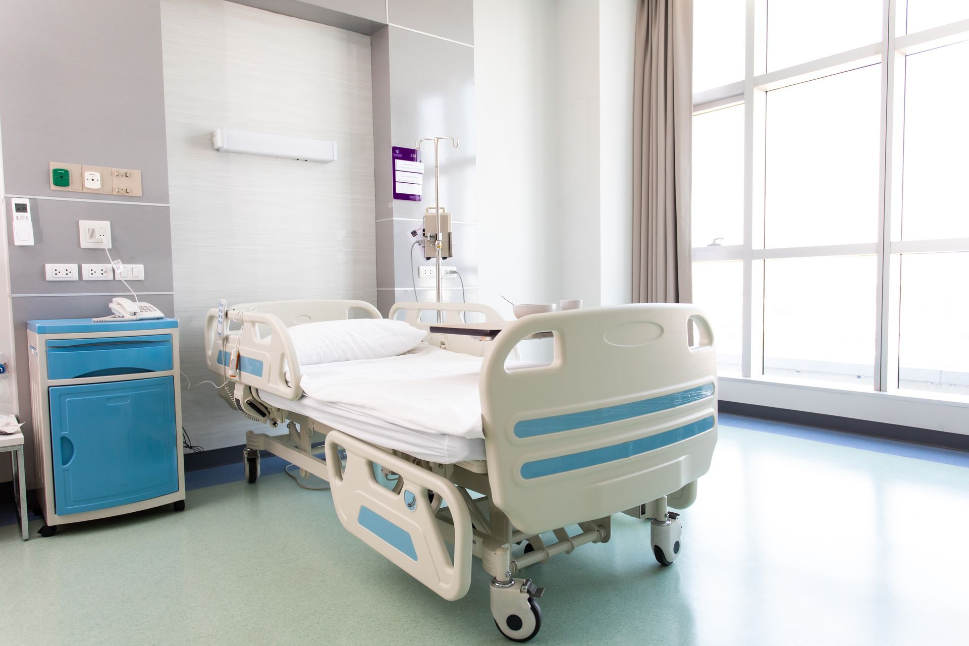 Lit d'hôpital avec des roues et un porte perfusion