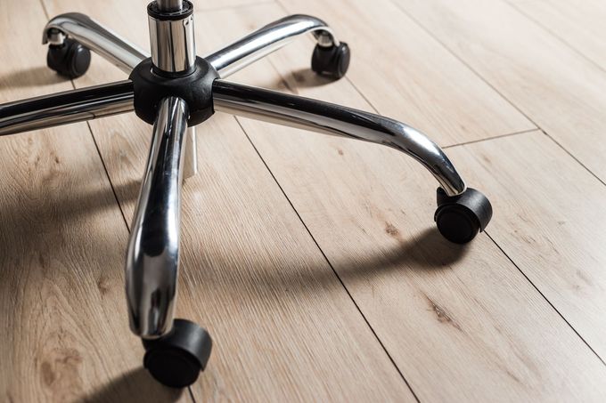 Roues de chaise de bureau sur du parquet
