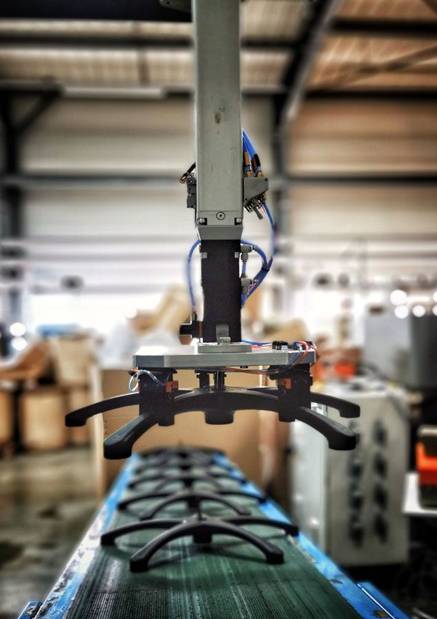 Machine en train de soulever une pièce en plastique