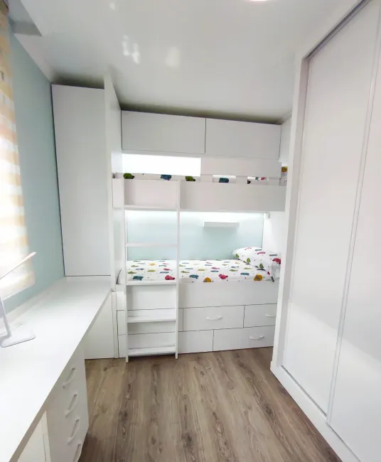 Un dormitorio con una litera y un escritorio.