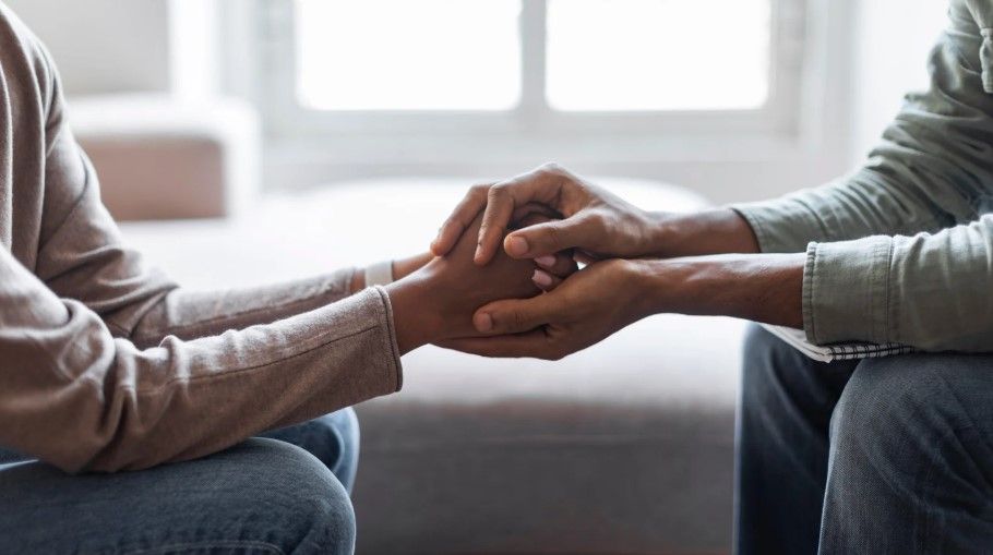 Manos entrelazadas, ofreciendo consuelo y apoyo.