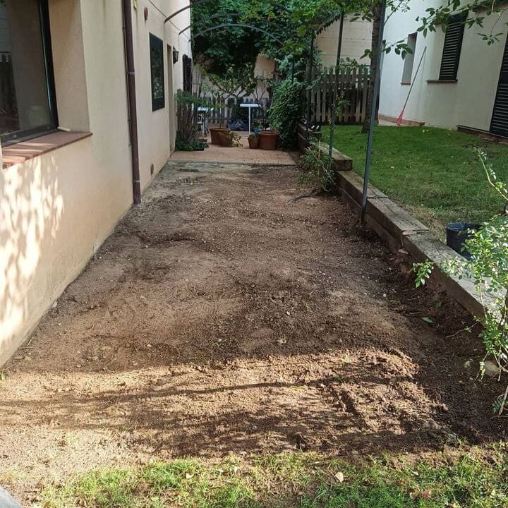 Un patio con mucha tierra y césped