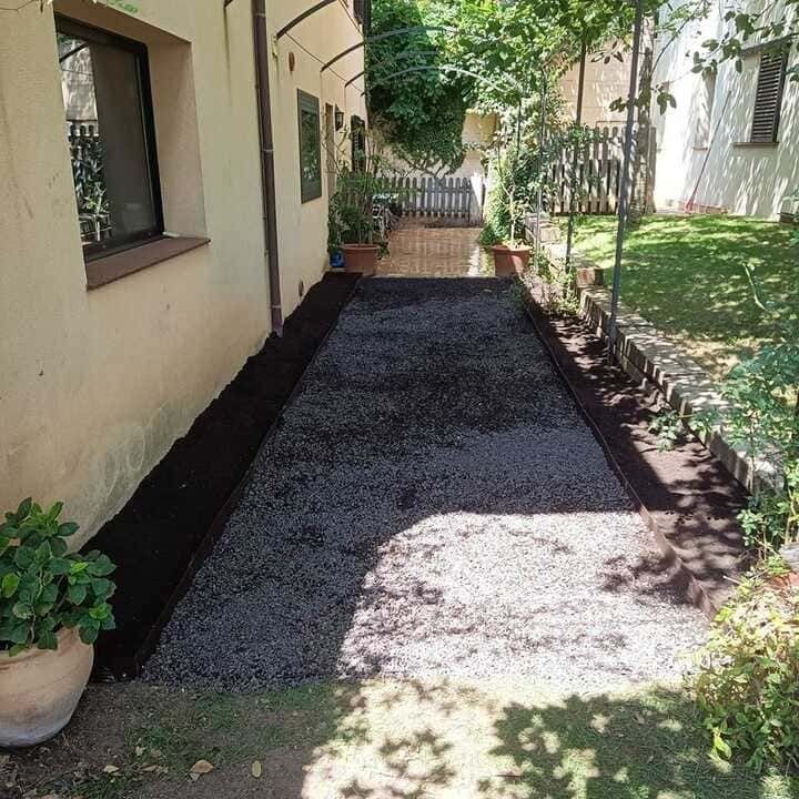 Una pasarela que conduce a una casa con una planta en maceta al costado.