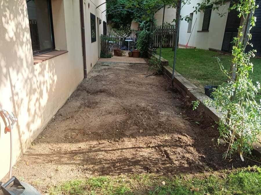 Un camino de tierra que conduce a una casa en un patio trasero.