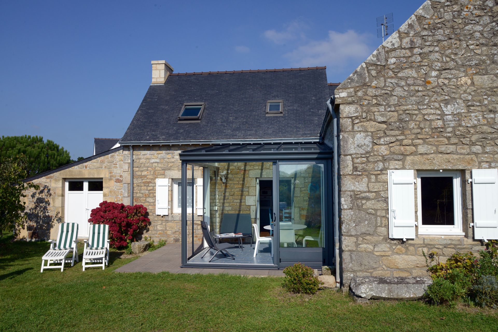 Véranda attenante à une maison en vieilles pierres
