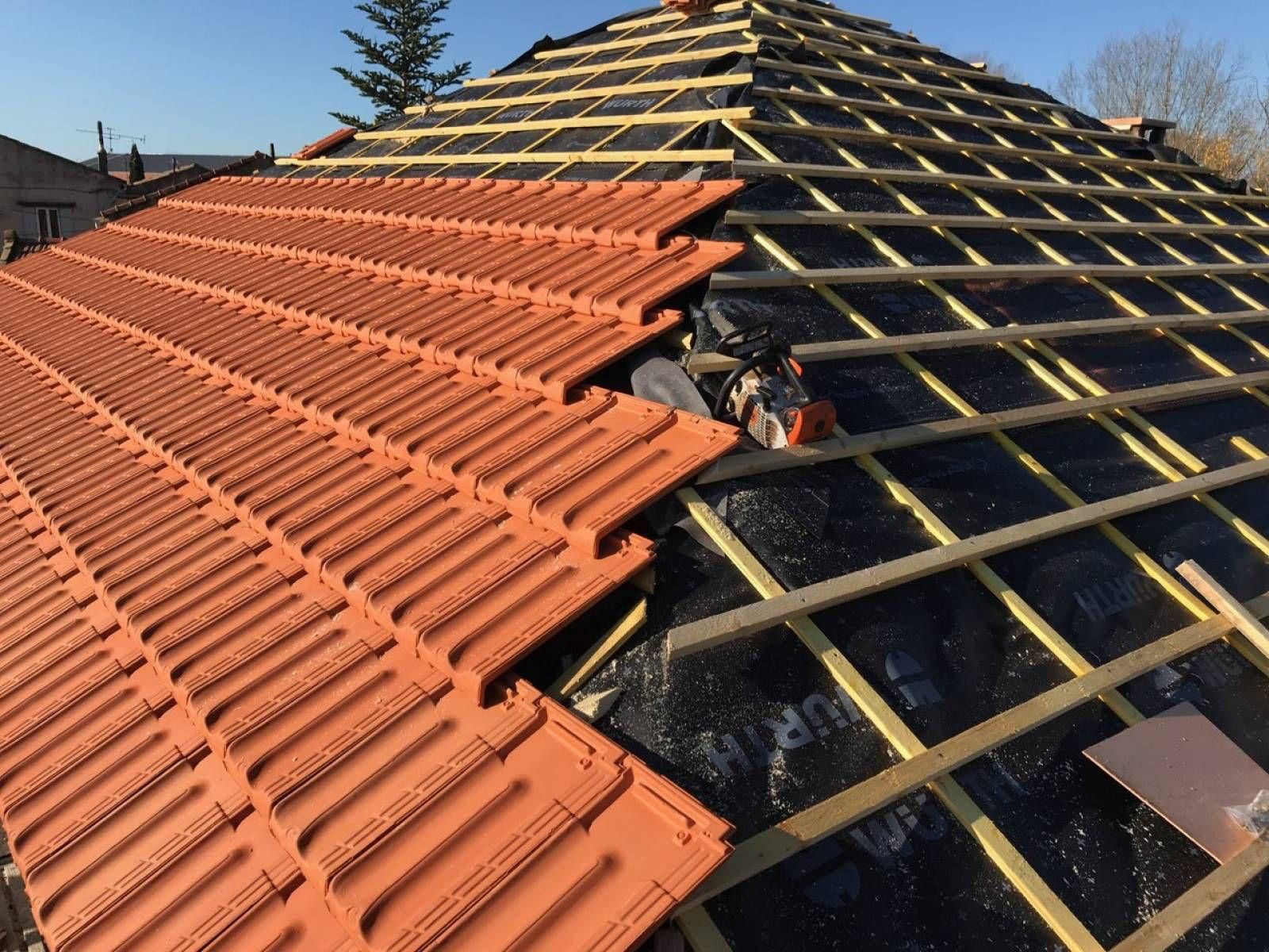 Toiture partiellement recouverte de tuiles rouges, l'autre moitié laissant apparaître les poutres en bois et la sous-couche.