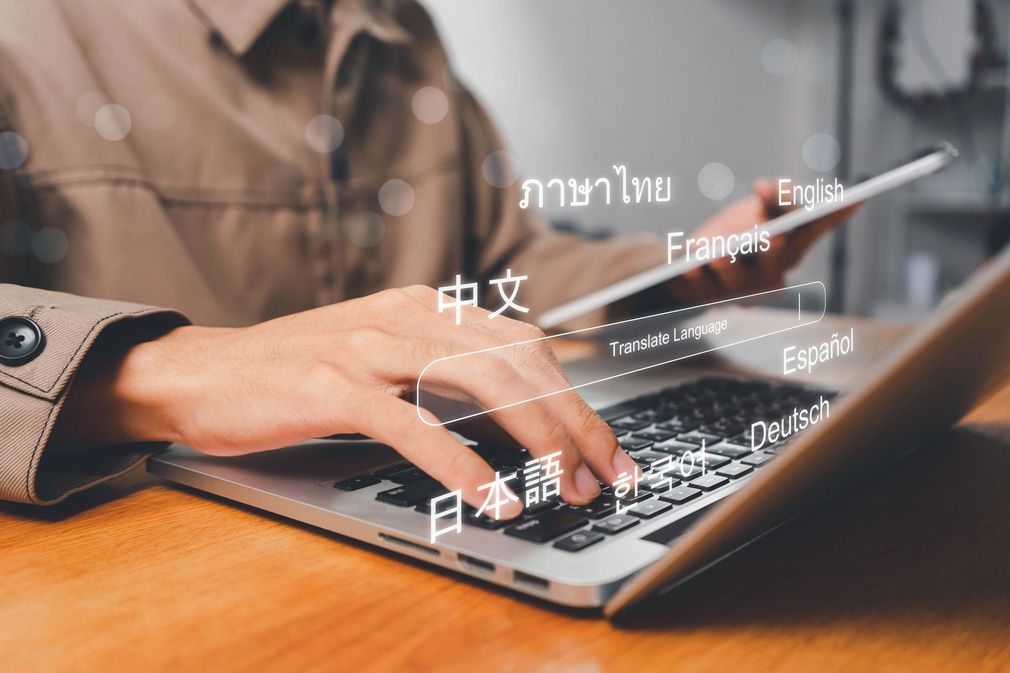 Une personne relit des documents tout en tapant sur un ordinateur portable à un bureau
