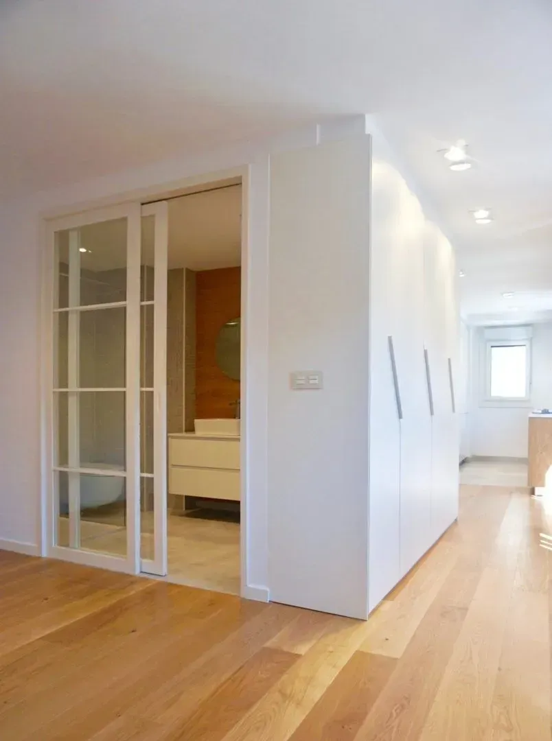 Dos hombres llevan un sofá a una casa.