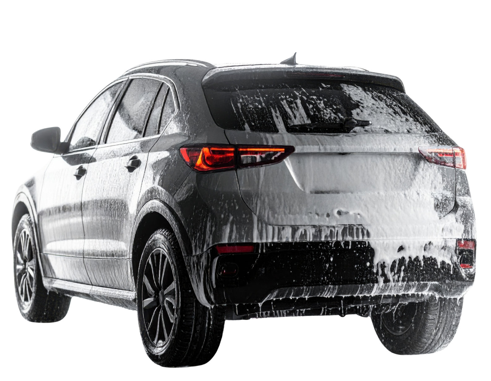 Un SUV recouvert de mousse blanche est en cours de lavage.