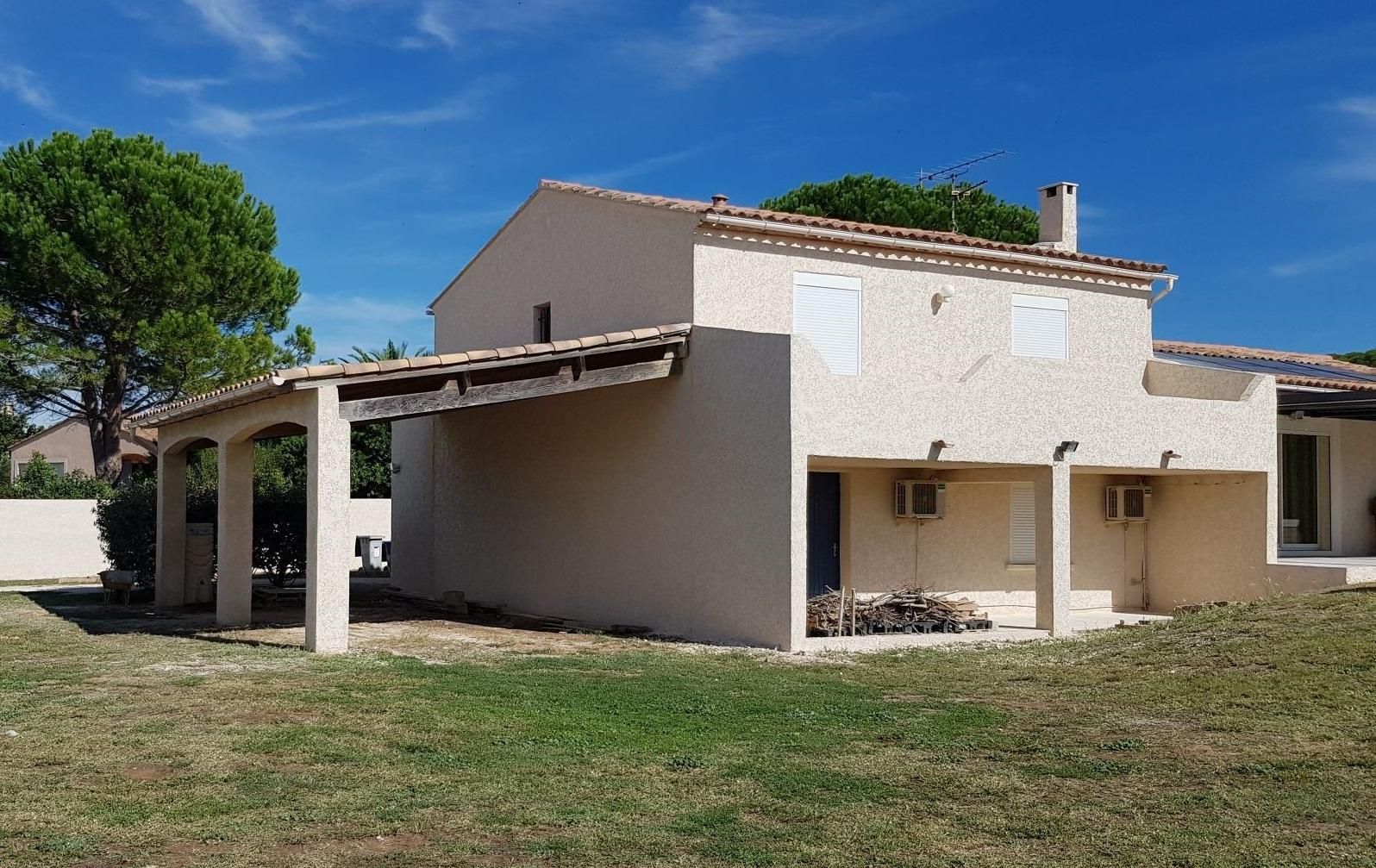 Façade repeinte avec un tas de bois devant la porte