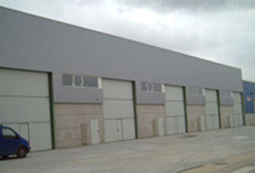 Una camioneta azul está estacionada frente a un edificio