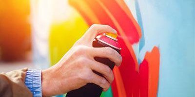 Una persona está pintando una pared con un aerosol.