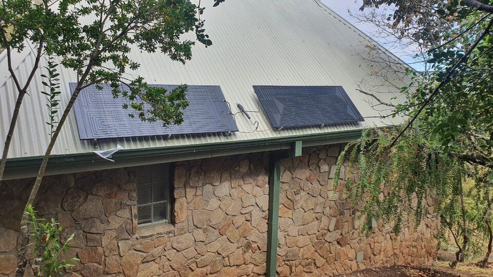 Il y a deux panneaux solaires sur le toit d'une maison.