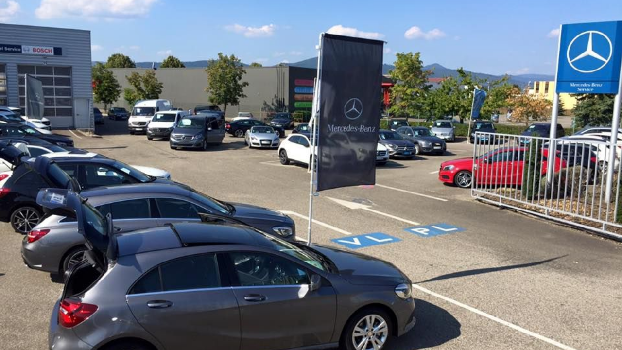 Parking extérieur du garage avec des voitures et utilitaires d'occasion.