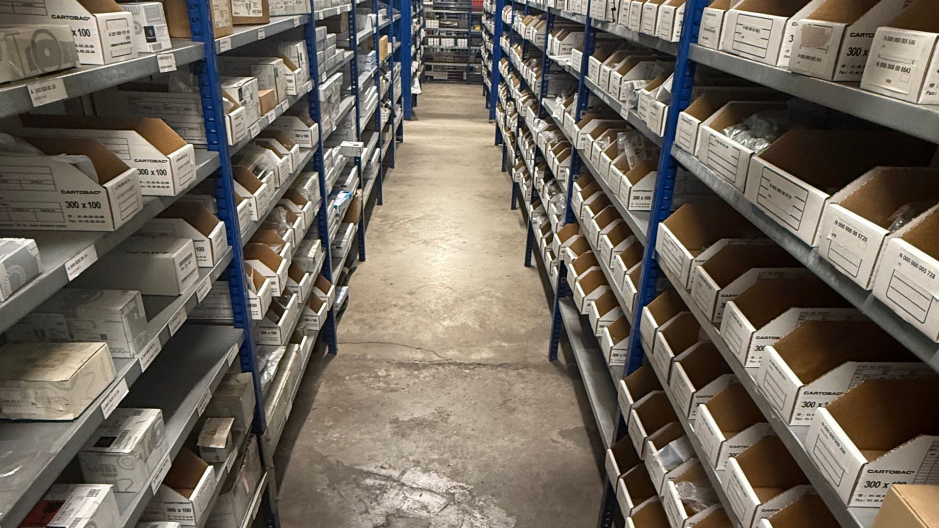 Cartons de pièces détachées sur des étagères.