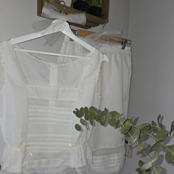 Blusas sin mangas con estampado floral colgadas en un perchero con etiquetas de precio.