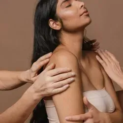 Una mujer está recibiendo un masaje de un grupo de personas.