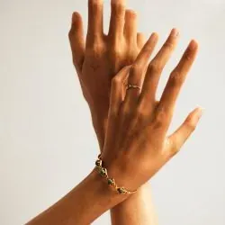 Una mujer lleva una pulsera y un anillo en su muñeca.