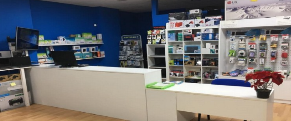 Una tienda de informática con muchos estantes y escritorios.