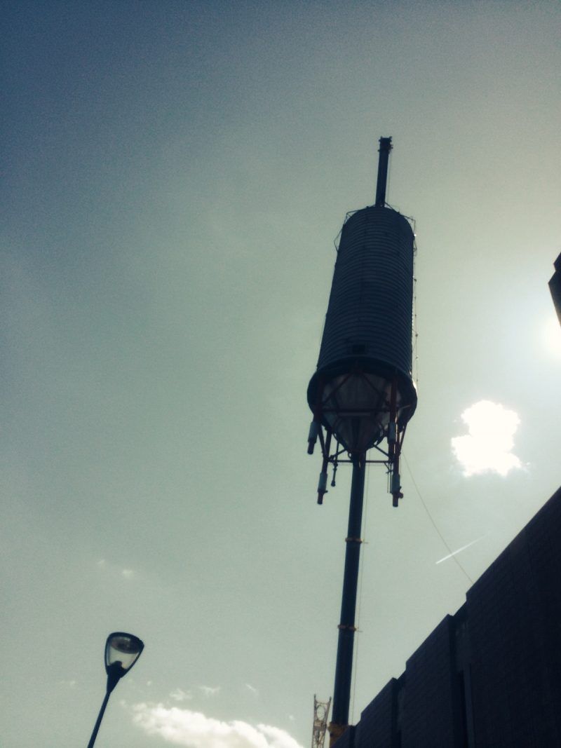 Haut silo industriel se détachant sur un ciel lumineux.