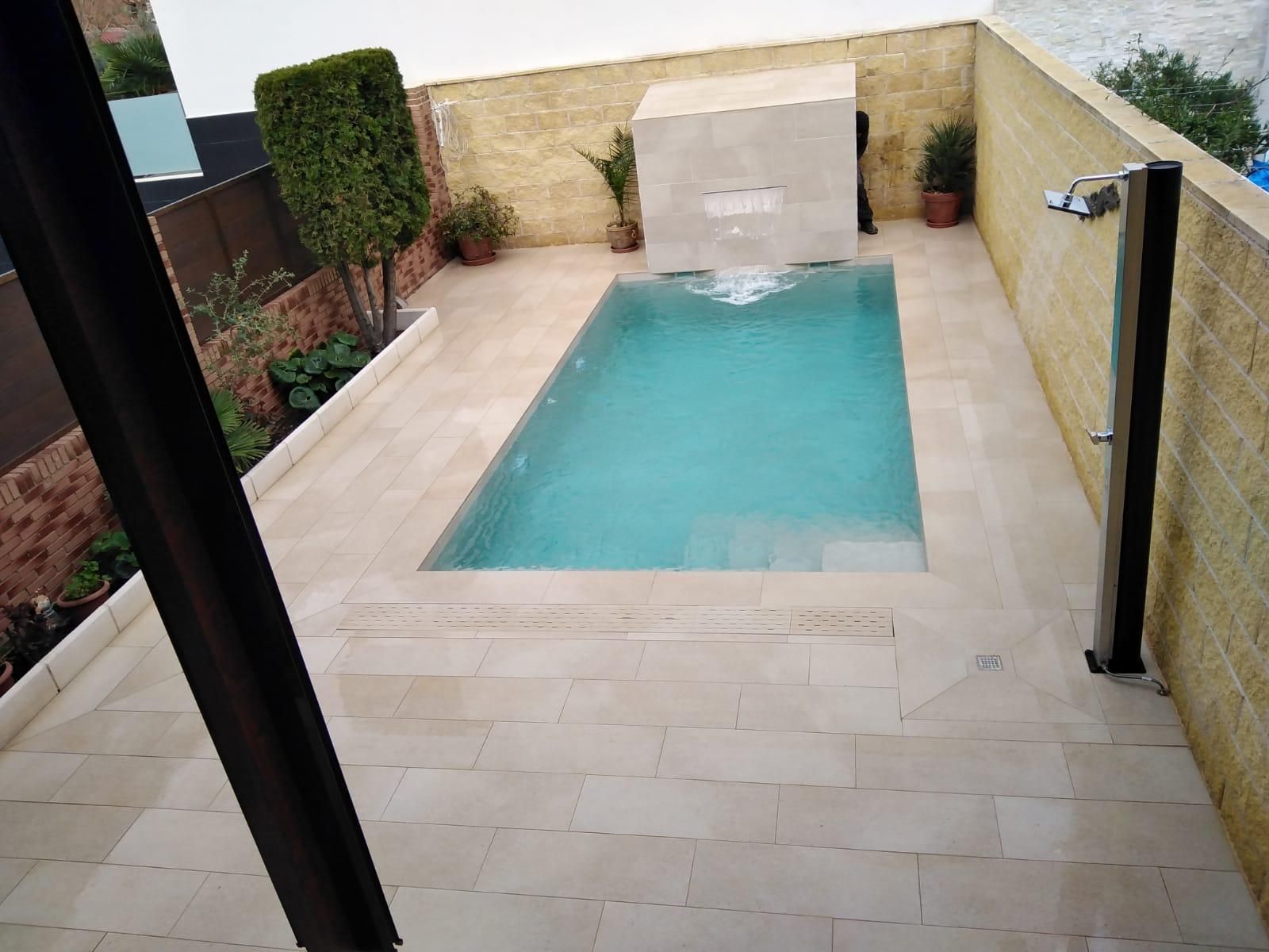 Una pequeña piscina con una cascada al fondo.