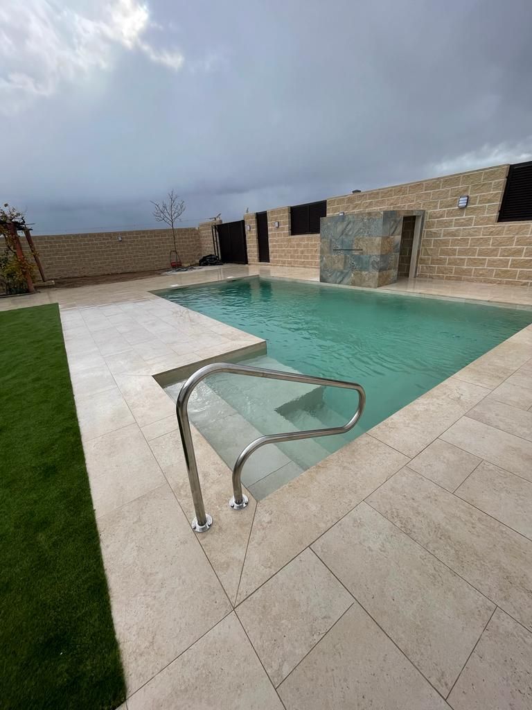 Una gran piscina con escaleras que conducen a ella en un patio trasero.