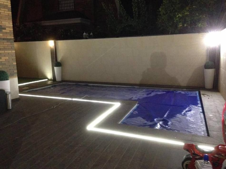 Una piscina que está iluminada por la noche