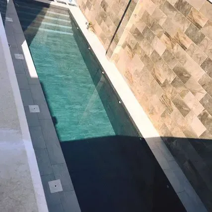 Una gran piscina está rodeada por un muro de piedra.