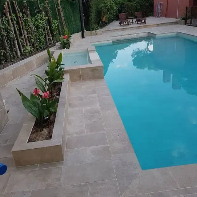 Una gran piscina rodeada de plantas y sillas.