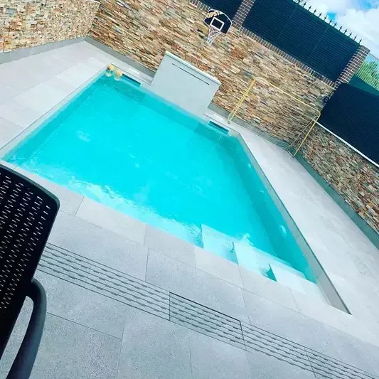 Una gran piscina con una silla delante de ella.