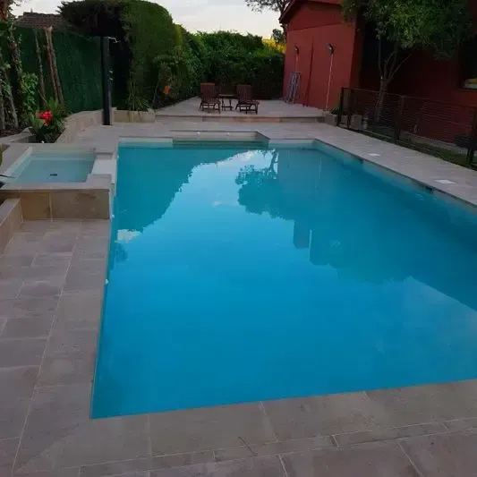 Hay una gran piscina en el patio trasero de una casa.