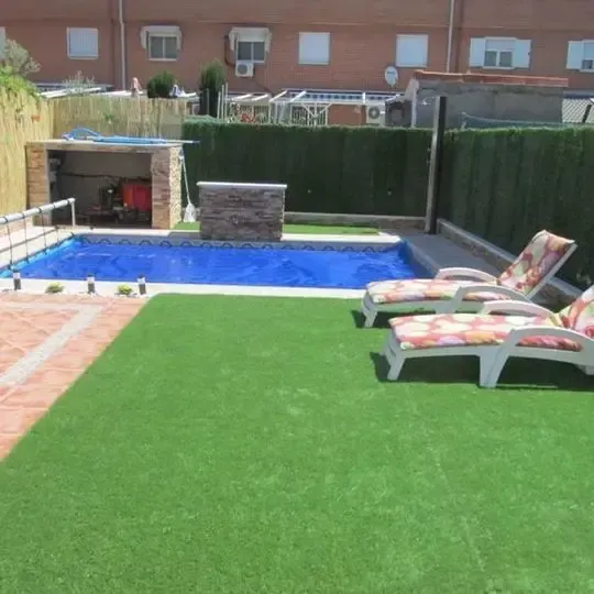 Un patio trasero con piscina y sillas de jardín.