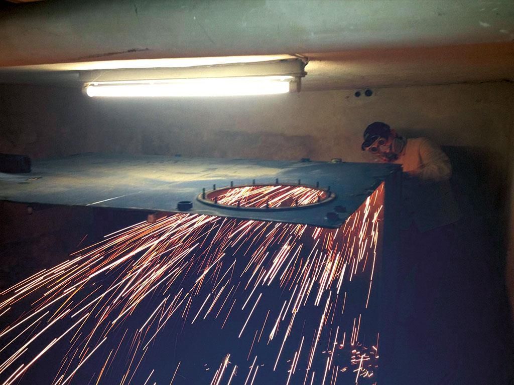 Ein Mann schneidet ein Stück Metall, aus dem Funken kommen