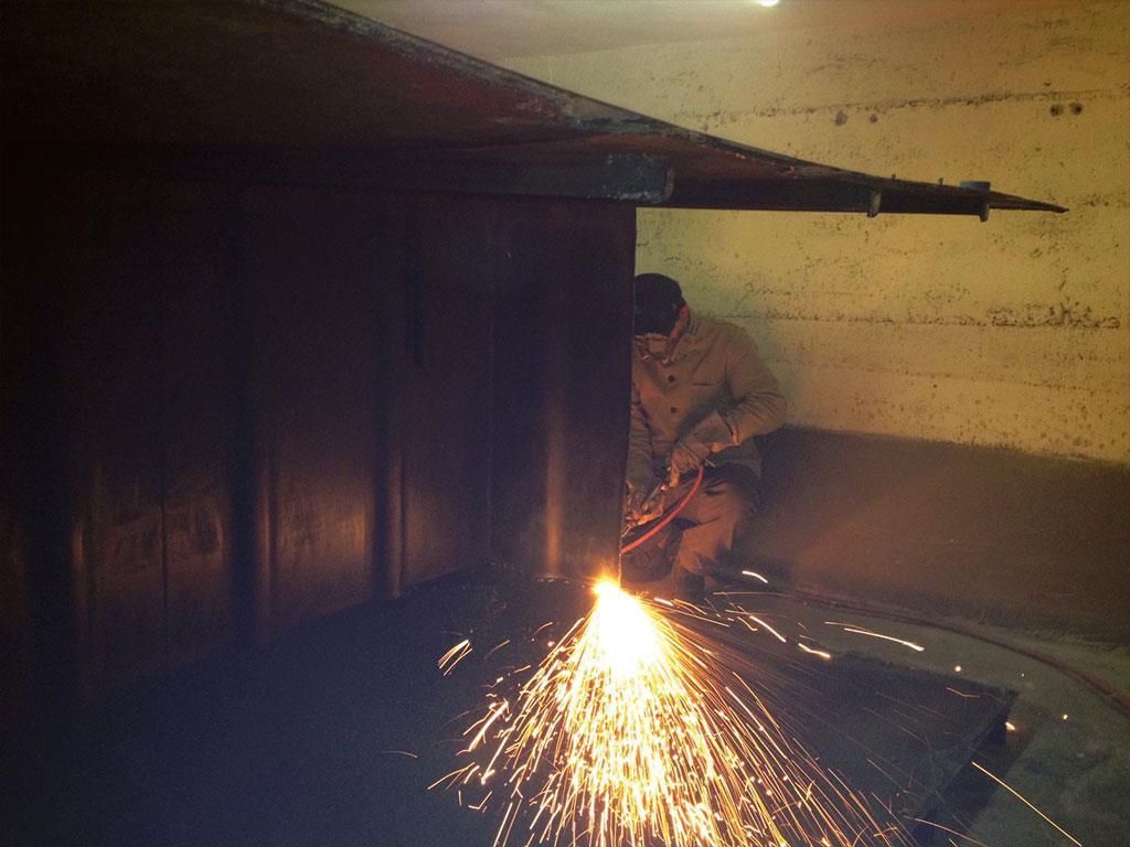 Ein Mann schneidet ein Stück Metall, aus dem Funken kommen