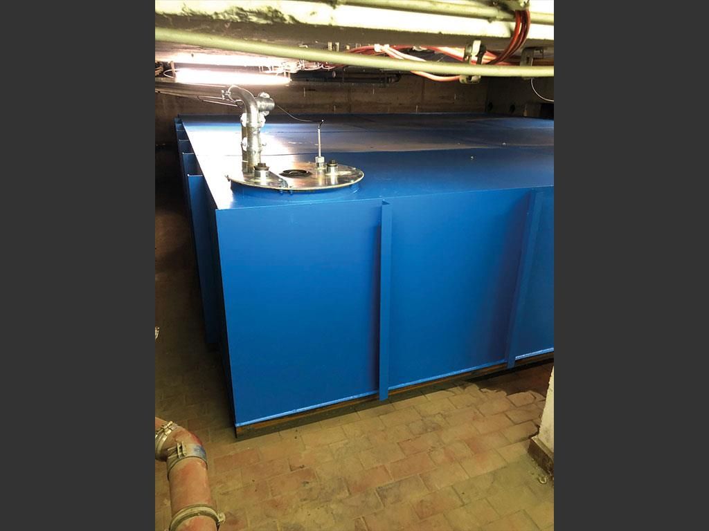 Ein großer blauer Tank steht auf einem gefliesten Boden