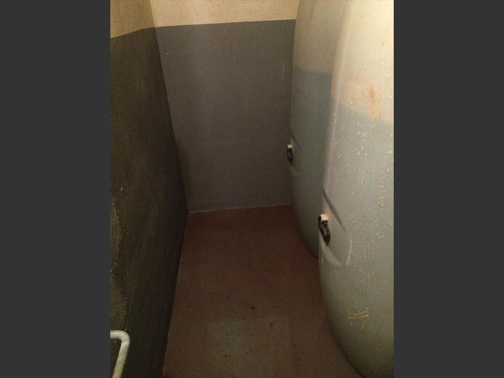 Ein Badezimmer mit zwei grauen Wänden und einem grauen Boden