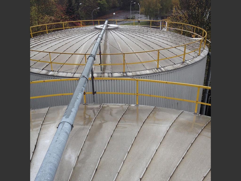 Ein großer Metalltank mit einem gelben Geländer darum