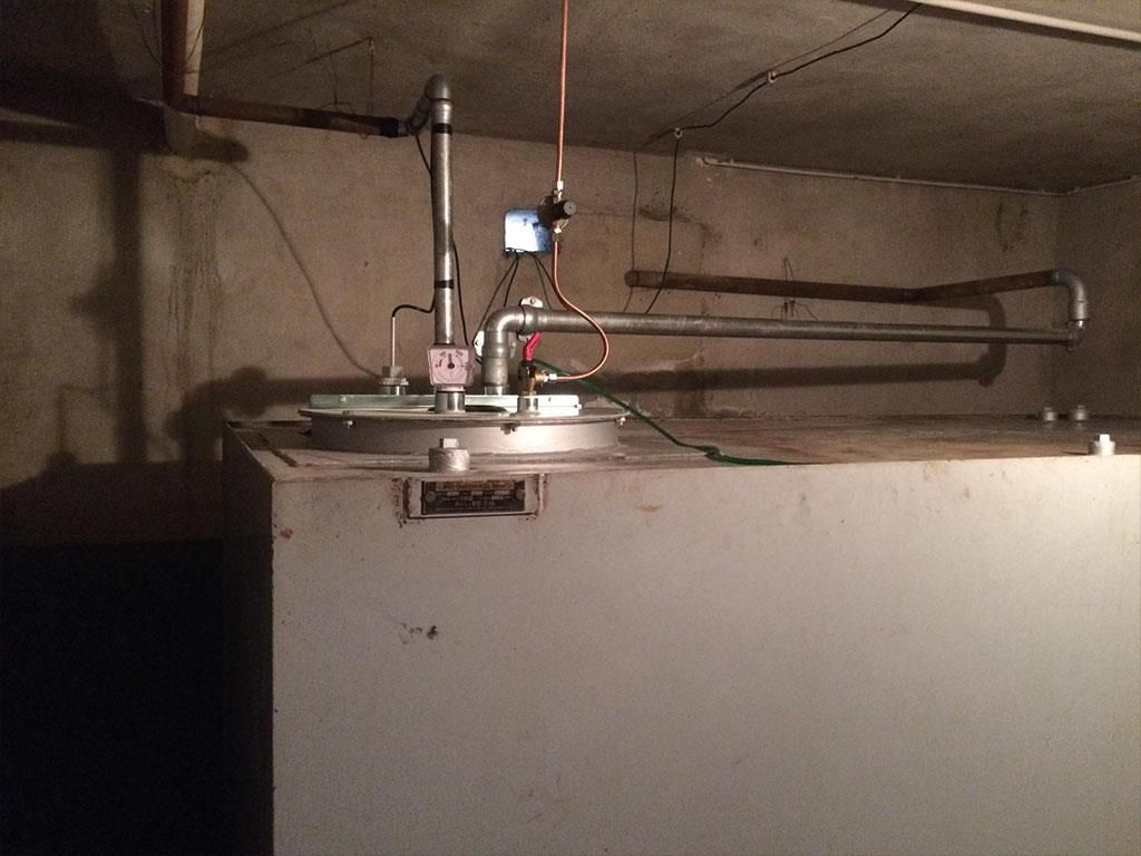 Ein Grauwassertank mit einem von der Decke hängenden Kupferrohr