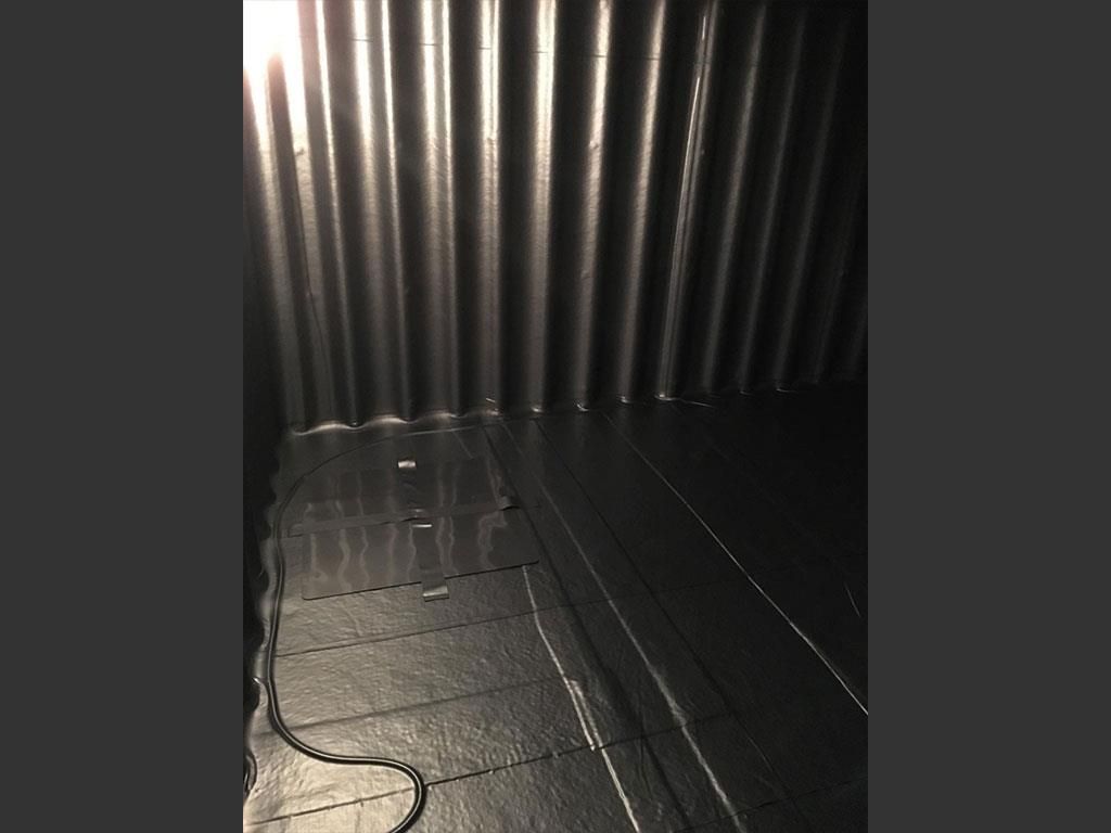 Ein dunkler Raum, durch dessen Wände Licht scheint.