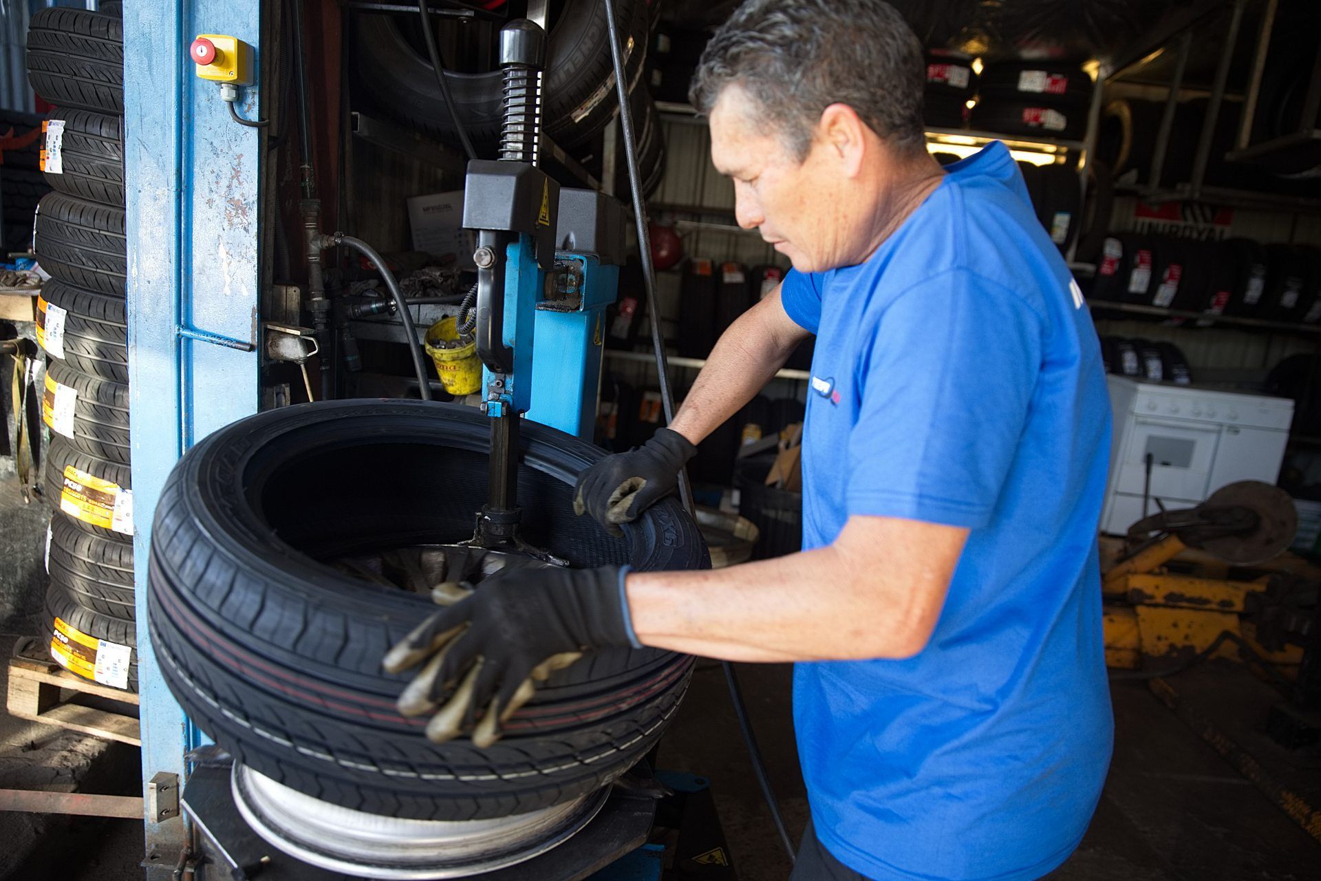 Mécanicien qui remonte une roue sur une voiture 