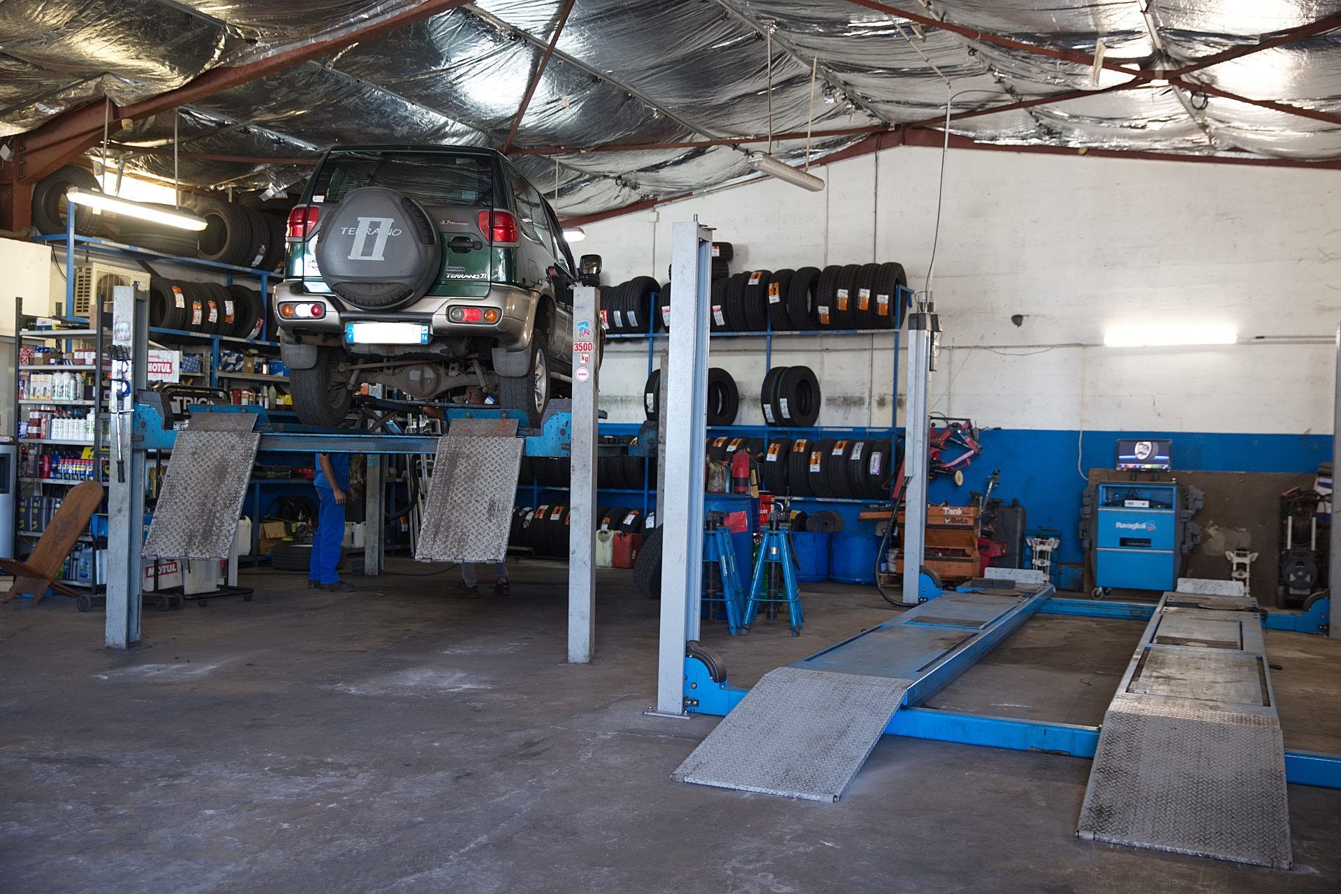 SUV sur le pont élévateur dans le garage Inter Pneus