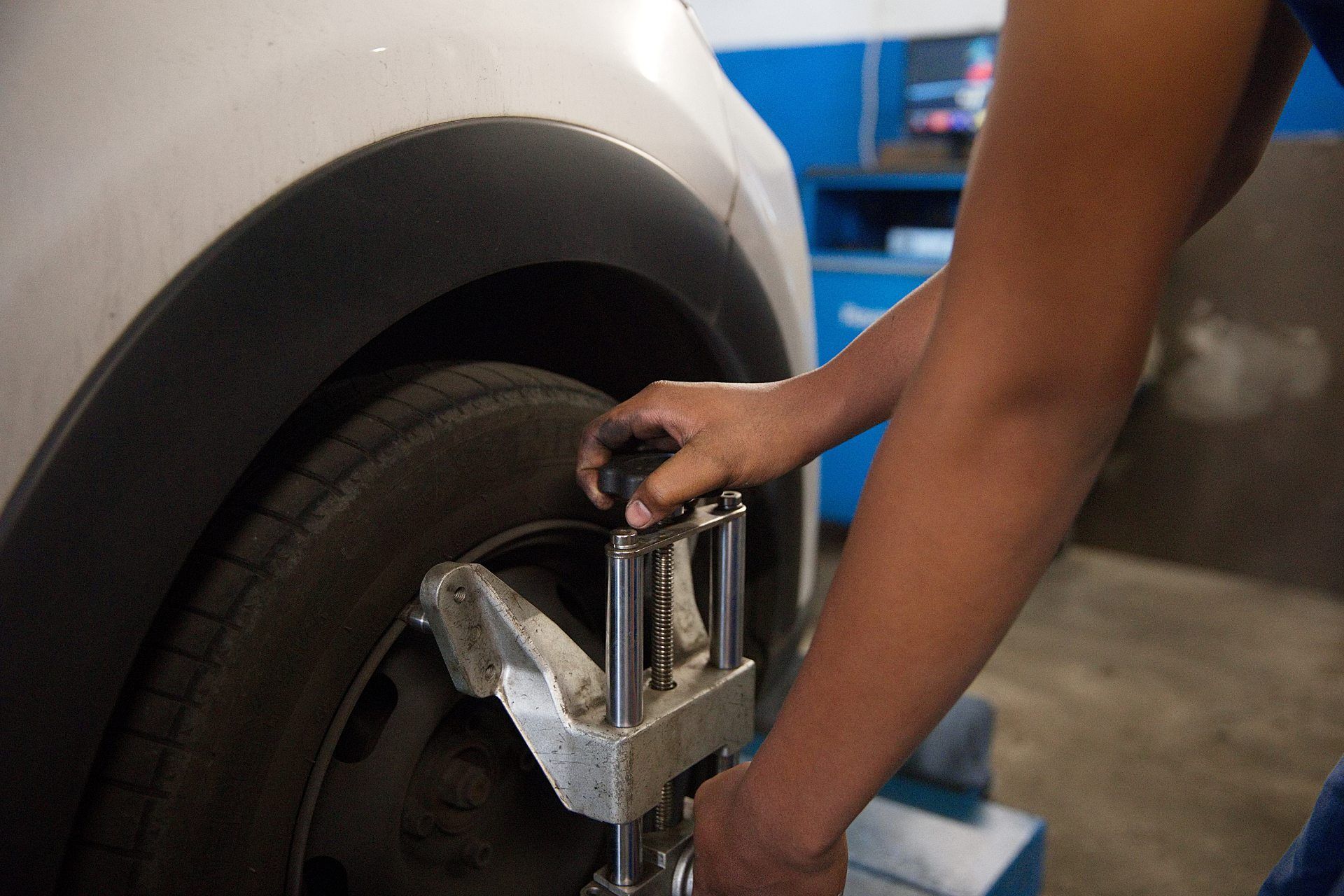 Mécanicien qui remonte une roue sur une voiture